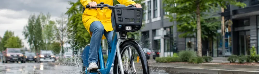 Bike-Sharing Ridership station on a rainy city street with cyclists and docked bikes